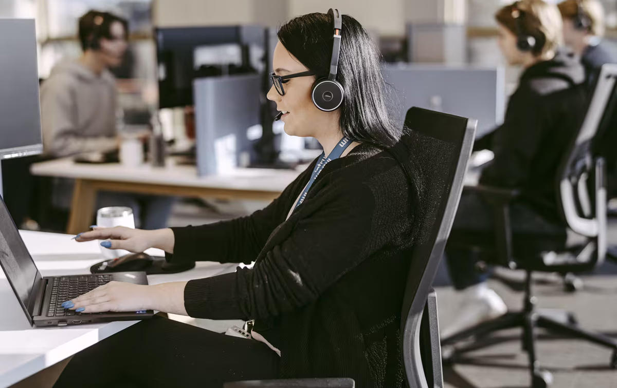 Intrum Call Center Mitarbeiterin bei der Arbeit am Labtop.