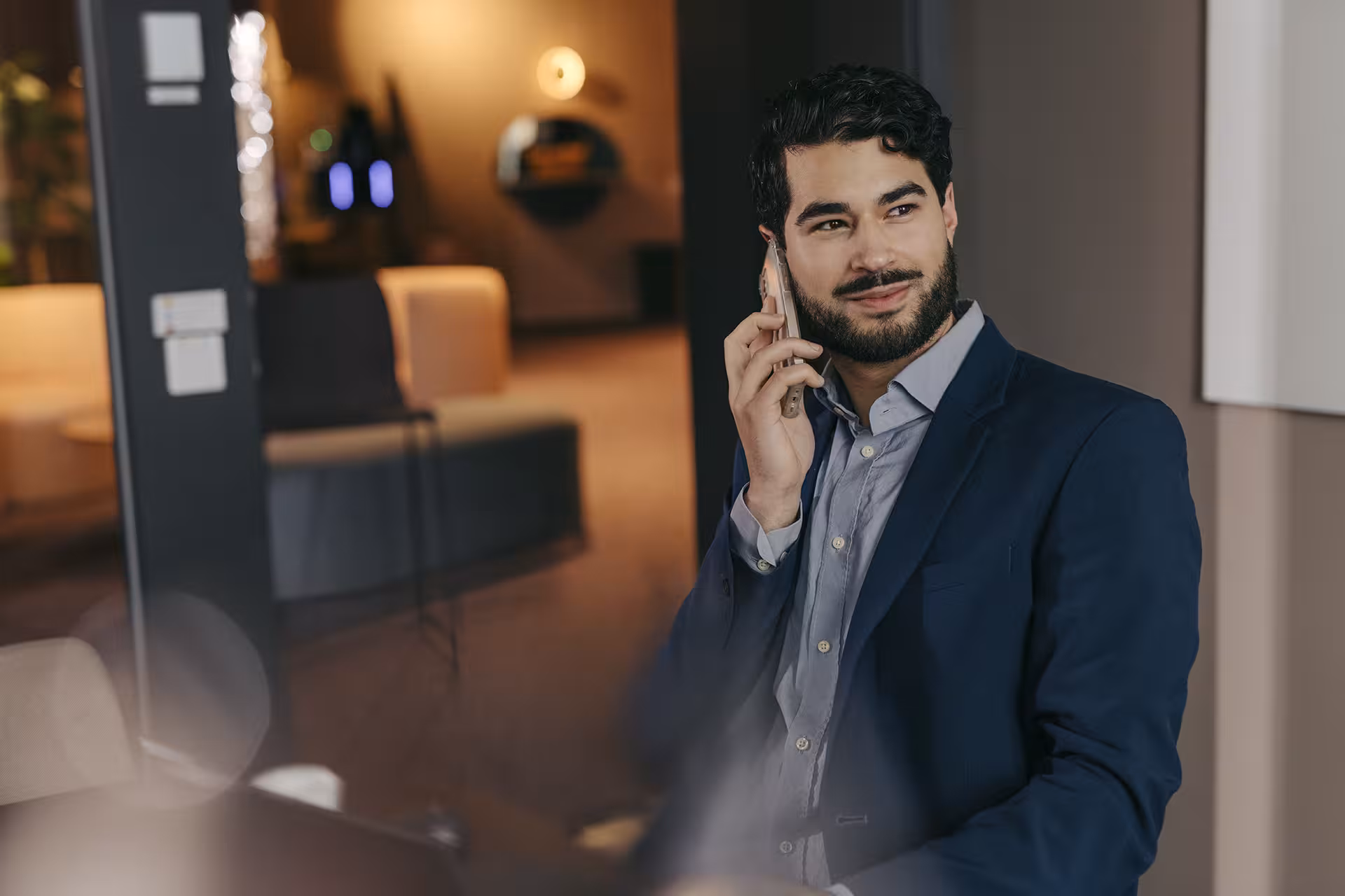 Ein Mann sitzt und hält sein Smartphone an sein Ohr