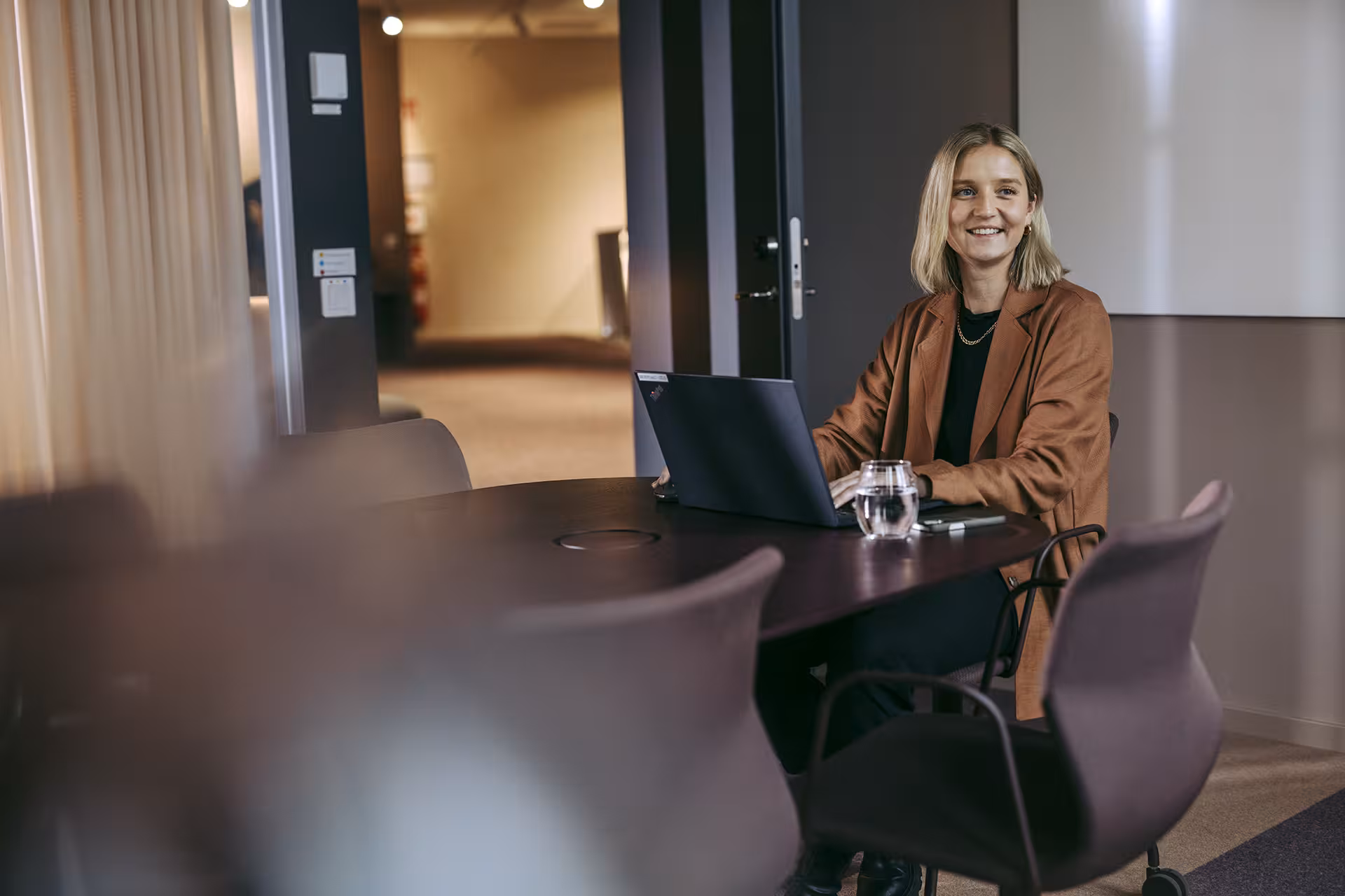 Forøyd dame som jobber på sin laptop